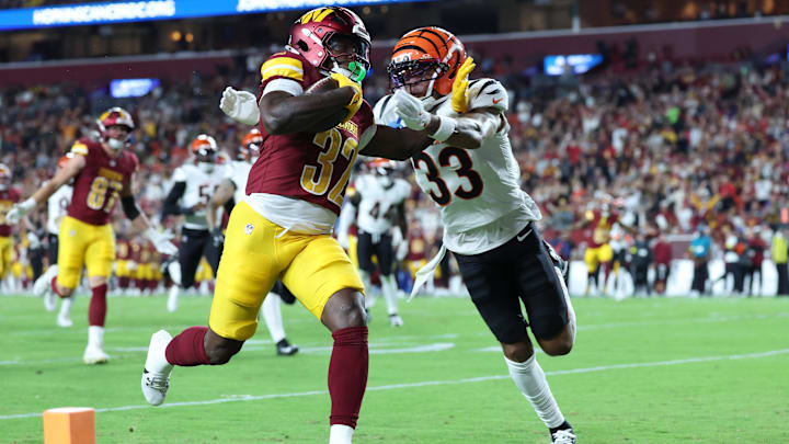 Aug 18, 2025; Landover, Maryland, USA; Washington Commanders running back Jacory Croskey-Merritt (32) scores a touchdown as Cincinnati Bengals safety Daijahn Anthony (33) defends during the first half at Northwest Stadium. Mandatory Credit: Amber Searls-Imagn Images