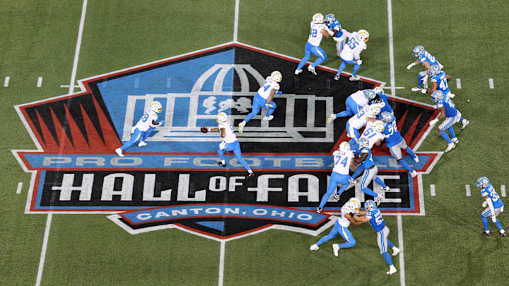Jul 31, 2025; Canton, Ohio, USA;  Los Angeles Chargers quarterback Trey Lance (5) hands off to running back Hassan Haskins (28) in the third quarter against the Detroit Lions at Tom Benson Hall of Fame Stadium. Mandatory Credit: Scott Galvin-Imagn Images