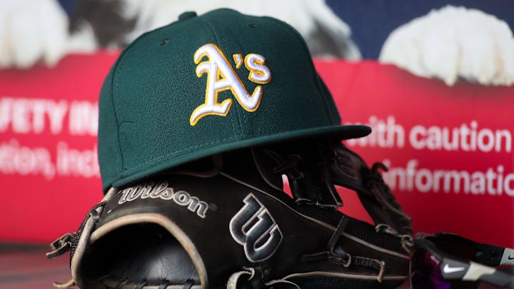 Jun 1, 2024; Atlanta, Georgia, USA; A detailed view of an Oakland Athletics hat and glove on the field against the Atlanta Braves in the sixth inning at Truist Park. Mandatory Credit: Brett Davis-Imagn Images Jun 1, 2024; Atlanta, Georgia, USA; A detailed view of an Oakland Athletics hat and glove on the field against the Atlanta Braves in the sixth inning at Truist Park. Mandatory Credit: Brett Davis-Imagn Images