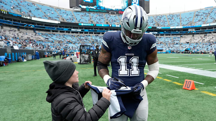 Dallas Cowboys linebacker Micah Parsons signs a jersey for a fan before the game at Bank of America Stadium. 