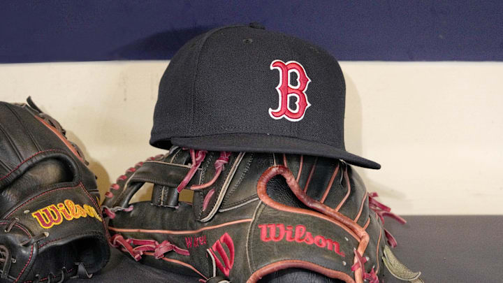 May 27, 2025; Milwaukee, Wisconsin, USA; A Boston Red Sox hat and glove sit in the dug out before a game against the Milwaukee Brewers at American Family Field. Mandatory Credit: Michael McLoone-Imagn Images