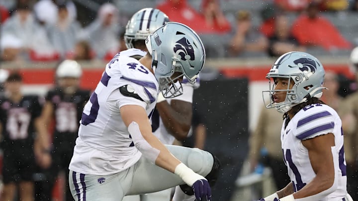 Nov 2, 2024; Houston, Texas, USA; Kansas State Wildcats linebacker Austin Romaine (45) steps over Houston Cougars running back J'Marion Burnette (20) after Burnette was tackled for a loss in the first quarter at TDECU Stadium. Mandatory Credit: Thomas B. Shea-Imagn Images