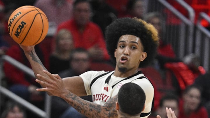 Jan 18, 2025; Louisville, Kentucky, USA; Louisville Cardinals guard Chucky Hepburn (24) looks to pass over Virginia Cavaliers guard Ishan Sharma (9) during the second half at KFC Yum! Center. Louisville defeated Virginia 81-67. Mandatory Credit: Jamie Rhodes-Imagn Images