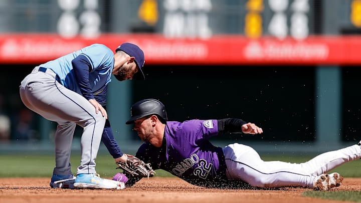 Apr 7, 2024; Denver, Colorado, USA; Colorado Rockies left fielder Nolan Jones (22) is tagged out attempting to steal second against Tampa Bay Rays second baseman Brandon Lowe (8) in the second inning at Coors Field. Mandatory Credit: Isaiah J. Downing-Imagn Images