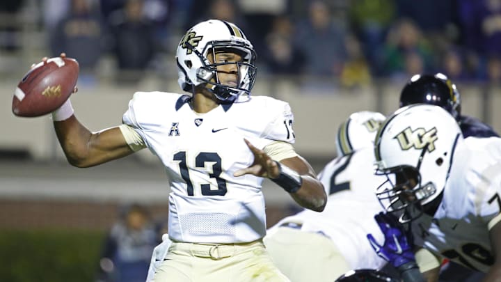 Dec 4, 2014; Greenville, NC, USA; Central Florida Knights quarterback Justin Holman (13) gets ready to throw a pass against the East Carolina Pirates at Dowdy-Ficklen Stadium. The Central Florida Knights defeated the East Carolina Pirates 32-30. Mandatory Credit: James Guillory-Imagn Images