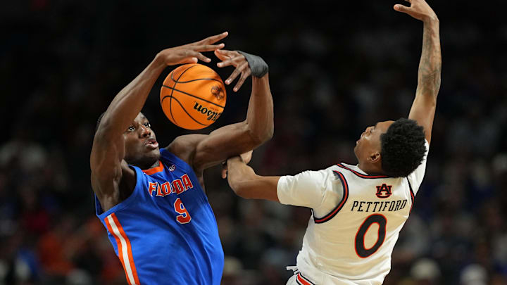 Apr 5, 2025; San Antonio, TX, USA; Florida Gators center Rueben Chinyelu (9) blocks and grabs the ball against Auburn Tigers guard Tahaad Pettiford (0) during the second half in the semifinals of the men's Final Four of the 2025 NCAA Tournament at the Alamodome. Mandatory Credit: Bob Donnan-Imagn Images