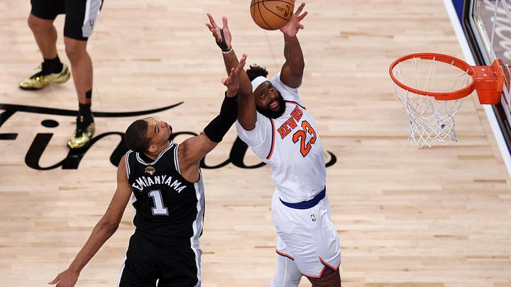 Jun 10, 2026; New York, New York, USA; New York Knicks center Mitchell Robinson (23) jumps to catch a pass and dunk the ball against San Antonio Spurs forward Victor Wembanyama (1)  during game four of the 2026 NBA Finals in the fourth quarter at Madison Square Garden. Mandatory Credit: Vincent Carchietta-Imagn Images