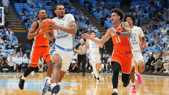 Feb 2, 2026; Chapel Hill, North Carolina, USA; North Carolina Tar Heels forward Jarin Stevenson (15) with the ball as Syracuse Orange guard JJ Starling (2) and guard Naithan George (11) defend in the second half at Dean E. Smith Center. Mandatory Credit: Bob Donnan-Imagn Images
