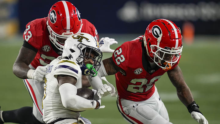 Nov 25, 2023; Atlanta, Georgia, USA; Georgia Tech Yellow Jackets wide receiver Malik Rutherford (8) is tackled by Georgia Bulldogs linebacker C.J. Allen (33) and defensive back Javon Bullard (22) during the second half at Hyundai Field. Mandatory Credit: Dale Zanine-Imagn Images