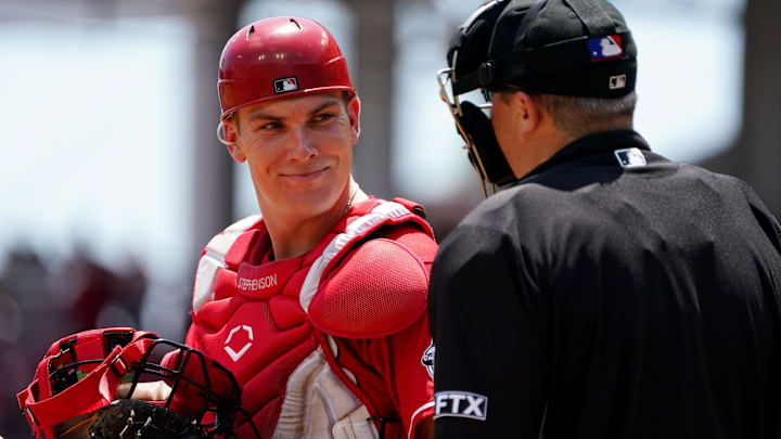 Cincinnati Reds catcher Tyler Stephenson (37) smiles toward the home plate umpire.