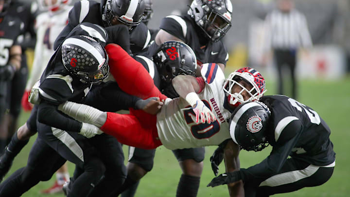 McKeesport's Kemon Spell (20) gets taken to the ground by multiple Aliquippa defenders during the second half of the WPIAL 4A Championship game Friday evening at Acrisure Stadium in Pittsburgh, PA.