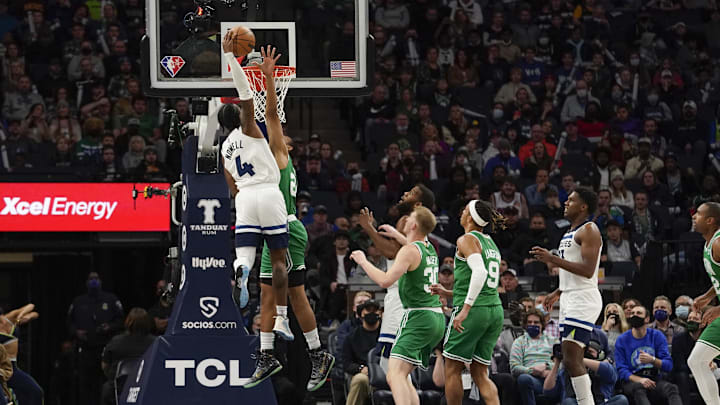 Minnesota Timberwolves guard Jaylen Nowell (4) dunks the ball over Boston Celtics forward Jabari Parker (20) during the third quarter at Target Center. Mandatory Credit: Nick Wosika-Imagn Images
