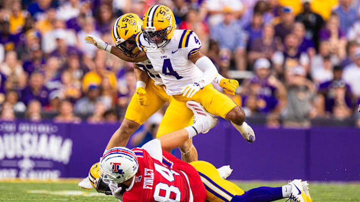 Sep 6, 2025; Baton Rouge, Louisiana, USA; LSU Tigers cornerback Mansoor Delane (4) is stopped on a play against Louisiana Tech Bulldogs tight end Eli Finley (84) during the first half against Louisiana Tech Bulldogs at Tiger Stadium. Mandatory Credit: Stephen Lew-Imagn Images Sep 6, 2025; Baton Rouge, Louisiana, USA; LSU Tigers cornerback Mansoor Delane (4) is stopped on a play against Louisiana Tech Bulldogs tight end Eli Finley (84) during the first half against Louisiana Tech Bulldogs at Tiger Stadium. Mandatory Credit: Stephen Lew-Imagn Images