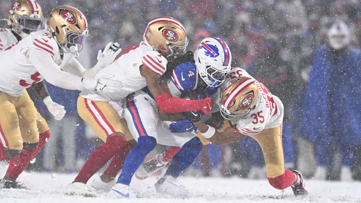 Dec 1, 2024; Orchard Park, New York, USA; Buffalo Bills running back James Cook (4) is tackled by San Francisco 49ers cornerback Nick McCloud (35) and cornerback Charvarius Ward (7) in the third quarter at Highmark Stadium.