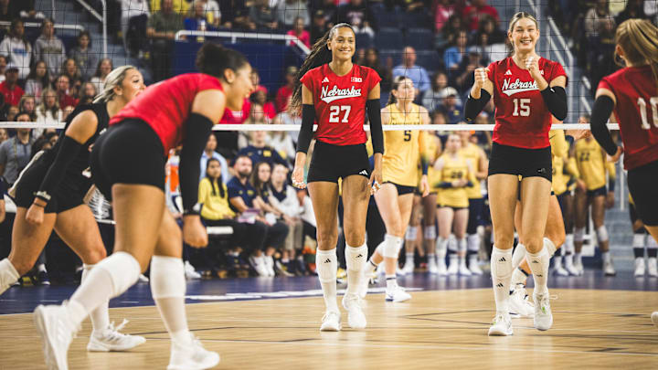 Harper Murray and Andi Jackson celebrate a point with their teammates Sunday at Michigan. Nebraska won its eighth straight Big Ten match in straight sets. 