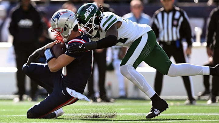 Oct 27, 2024; Foxborough, Massachusetts, USA; New England Patriots quarterback Drake Maye (10) is tackled by New York Jets linebacker Jamien Sherwood (44) during the first half at Gillette Stadium.