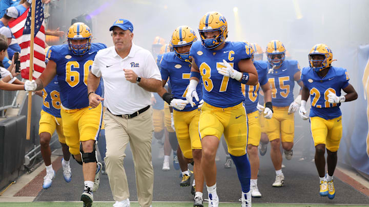Sep 27, 2025; Pittsburgh, Pennsylvania, USA;  Pittsburgh Panthers head coach Pat Narduzzi (white) and tight end Jake Overman (87) lead the team onto the field to play the Louisville Cardinals at Acrisure Stadium. Mandatory Credit: Charles LeClaire-Imagn Images