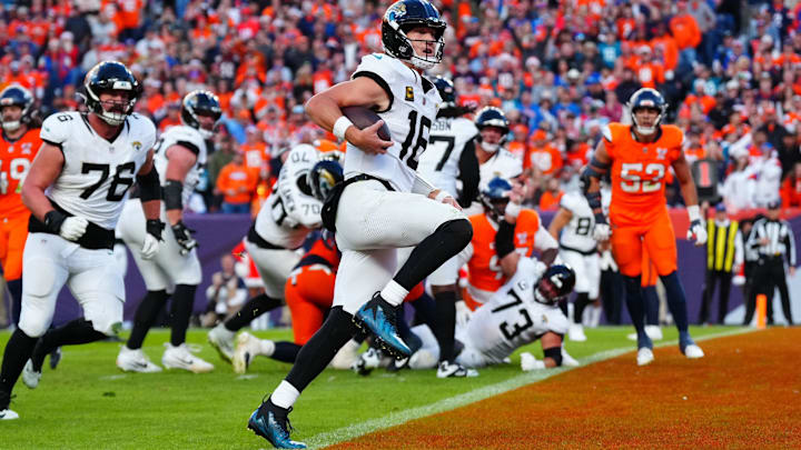 Dec 21, 2025; Denver, Colorado, USA; Jacksonville Jaguars quarterback Trevor Lawrence (16) rushes for a touchdown against the Denver Broncos during the second half at Empower Field at Mile High. Mandatory Credit: Ron Chenoy-Imagn Images