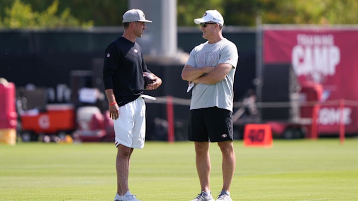Jul 28, 2021; Santa Clara, CA, USA;  San Francisco 49ers head coach Kyle Shanahan (left) and general manager John Lynch during training camp at the SAP Performance Facility.  Mandatory Credit: Stan Szeto-Imagn Images