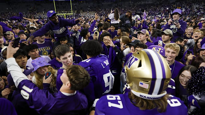 Huskies fans rush the field to to share in the UW's 27-17 victory over Michigan.