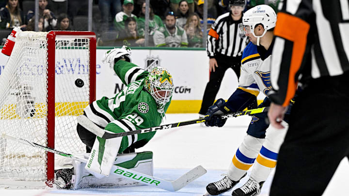 Apr 17, 2024; Dallas, Texas, USA; St. Louis Blues center Jordan Kyrou (25) looks on as his shot hits the crossbar behind Dallas Stars goaltender Jake Oettinger (29) during the overtime shootout at the American Airlines Center. Mandatory Credit: Jerome Miron-Imagn Images
