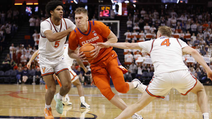 Mar 1, 2025; Charlottesville, Virginia, USA; Clemson Tigers center Viktor Lakhin (0) controls the ball between Virginia Cavaliers forward Jacob Cofie (5) and Cavaliers guard Andrew Rohde (4) during the first half at John Paul Jones Arena. Mandatory Credit: Amber Searls-Imagn Images