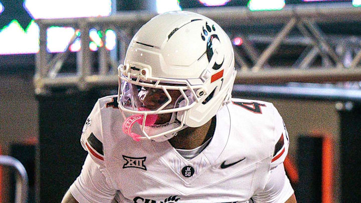 Oct 18, 2025; Stillwater, Oklahoma, USA; Cincinnati Bearcats offensive lineman Taran Tyo (77) lifts wide receiver Cyrus Allen (4) while celebrating a touchdown during the first half against the Oklahoma State Cowboys at Boone Pickens Stadium. Mandatory Credit: William Purnell-Imagn Images
