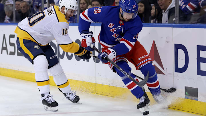 Mar 2, 2025; New York, New York, USA; New York Rangers defenseman Urho Vaakanainen (18) fights for the puck against Nashville Predators center Colton Sissons (10) during the first period at Madison Square Garden. Mandatory Credit: Brad Penner-Imagn Images
