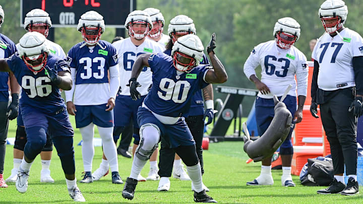 Jul 27, 2023; Foxborough, MA, USA; New England Patriots defensive tackle Christian Barmore (90) throws a weight bag during training camp at Gillette Stadium. Mandatory Credit: Eric Canha-Imagn Images