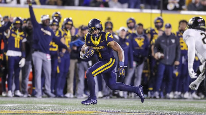 Nov 23, 2024; Morgantown, West Virginia, USA; West Virginia Mountaineers running back Jahiem White (1) runs the ball against the UCF Knights during the third quarter at Mountaineer Field at Milan Puskar Stadium. Mandatory Credit: Ben Queen-Imagn Images
