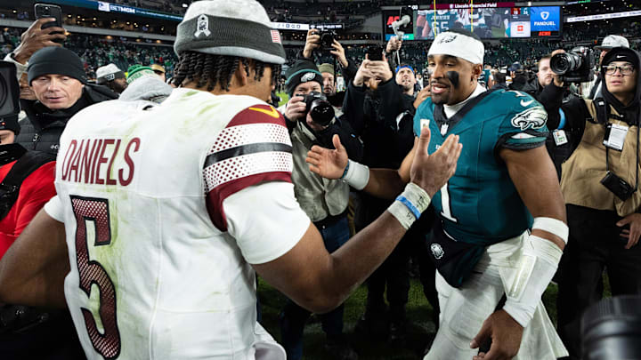 Philadelphia Eagles quarterback Jalen Hurts and Washington Commanders quarterback Jayden Daniels shake hands after an Eagles victory.