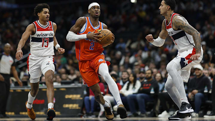 Jan 12, 2025; Washington, District of Columbia, USA; Oklahoma City Thunder guard Shai Gilgeous-Alexander (2) drives to the basket as Washington Wizards guard Jordan Poole (13) and Wizards forward Kyle Kuzma (33) defend in the third quarter at Capital One Arena.