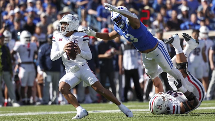 Oct 12, 2024; Provo, Utah, USA; Brigham Young Cougars defensive end Isaiah Bagnah (13) pressures Arizona Wildcats quarterback Noah Fifita (11) during the first quarter at LaVell Edwards Stadium. Mandatory Credit: Rob Gray-Imagn Images Oct 12, 2024; Provo, Utah, USA; Brigham Young Cougars defensive end Isaiah Bagnah (13) pressures Arizona Wildcats quarterback Noah Fifita (11) during the first quarter at LaVell Edwards Stadium. Mandatory Credit: Rob Gray-Imagn Images
