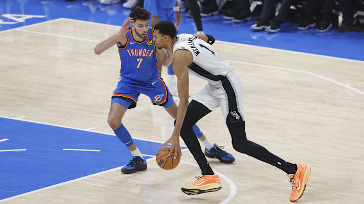 Jan 13, 2026; Oklahoma City, Oklahoma, USA; San Antonio Spurs forward/center Victor Wembanyama (1) drives to the basket past Oklahoma City Thunder center/forward Chet Holmgren (7) during the first quarter at Paycom Center.