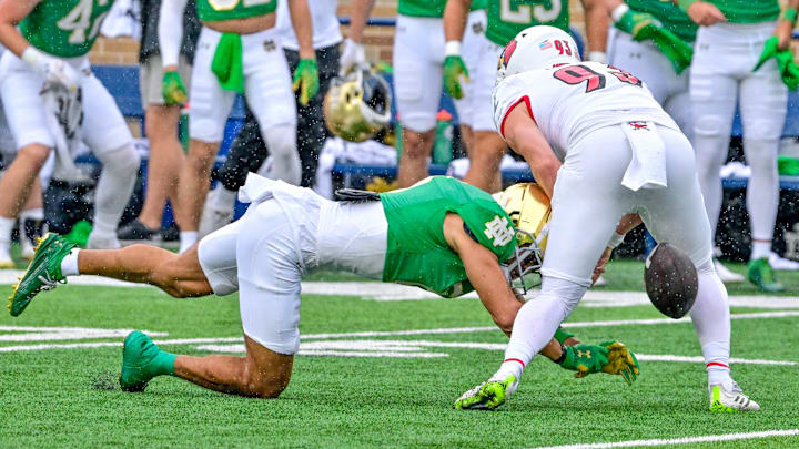 Sep 28, 2024; South Bend, Indiana, USA; Notre Dame Fighting Irish wide receiver Jordan Faison (6) chases down a mis-snapped punt as Louisville Cardinals punter Brady Hodges (93) also attempts to grab the ball on a Louisville punt attempt in the first quarter at Notre Dame Stadium. 