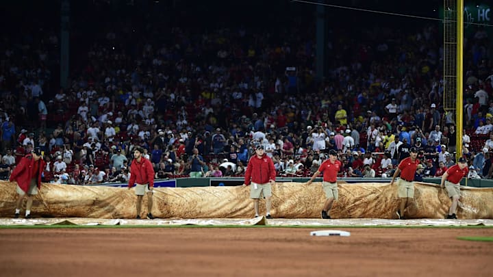 Jul 1, 2025; Boston, Massachusetts, USA; Boston Red Sox grounds crew pulls the tarp on the field during a rain delay in the third inning against the Cincinnati Reds at Fenway Park. Mandatory Credit: Bob DeChiara-Imagn Images Jul 1, 2025; Boston, Massachusetts, USA; Boston Red Sox grounds crew pulls the tarp on the field during a rain delay in the third inning against the Cincinnati Reds at Fenway Park. Mandatory Credit: Bob DeChiara-Imagn Images