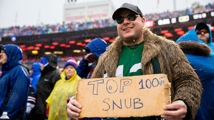 A fan holds a sign reading "Top 100 Snub" at a New York Jets game against Buffalo. 