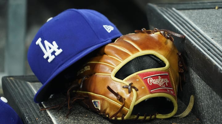 Apr 28, 2024; Toronto, Ontario, CAN; A hat and glove of an Los Angeles Dodgers player durng a game against the Toronto Blue Jays at Rogers Centre. Mandatory Credit: John E. Sokolowski-Imagn Images