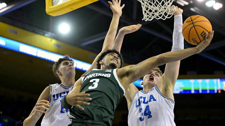 Feb 4, 2025; Los Angeles, California, USA; Michigan State Spartans guard Jaden Akins (3) scores past the defense of UCLA Bruins center Aday Mara (15) and forward Tyler Bilodeau (34) in the second half at Pauley Pavilion presented by Wescom. Mandatory Credit: Jayne Kamin-Oncea-Imagn Images