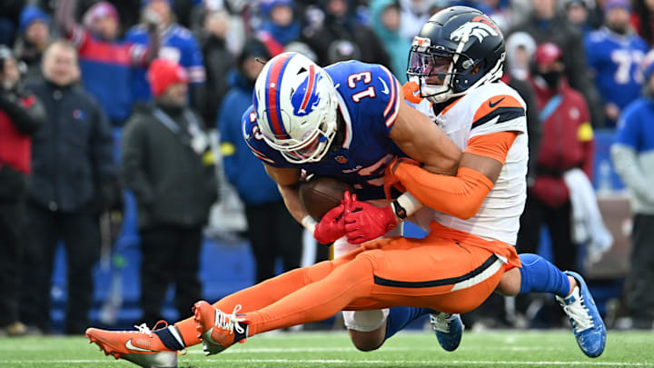 Jan 12, 2025; Orchard Park, New York, USA; Buffalo Bills wide receiver Mack Hollins (13) is tackled by Denver Broncos cornerback Pat Surtain II (2) during the fourth quarter in an AFC wild card game at Highmark Stadium. 