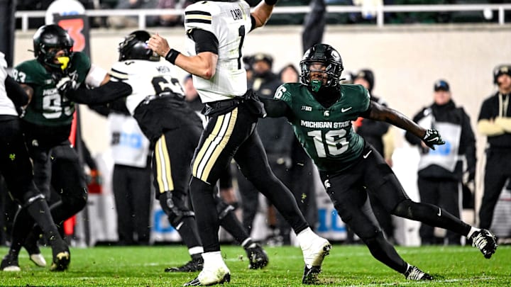 Michigan State's Jaylen Thompson, right, pressures Purdue's Hudson Card during the fourth quarter on Friday, Nov. 22, 2024, at Spartan Stadium in East Lansing.