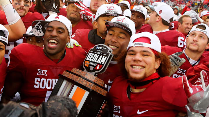 Dec 3, 2016; Norman, OK, USA;  Oklahoma Sooners players celebrate with the Bedlam series trophy after the game against the Oklahoma State Cowboys at Gaylord Family - Oklahoma Memorial Stadium. Mandatory Credit: Kevin Jairaj-Imagn Images
