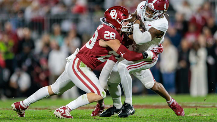 Alabama quarterback Jalen Milroe (4) is tackled by Oklahoma linebacker Danny Stutsman. Alabama quarterback Jalen Milroe (4) is tackled by Oklahoma linebacker Danny Stutsman.