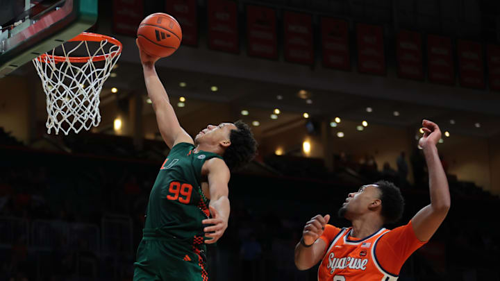 Feb 11, 2025; Coral Gables, Florida, USA; Miami Hurricanes guard Divine Ugochukwu (99) drives to the basket past Syracuse Orange guard J.J. Starling (2) during the second half at Watsco Center. Mandatory Credit: Sam Navarro-Imagn Images