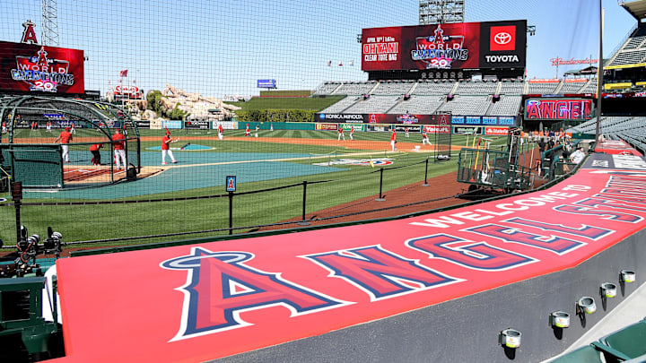 Apr 7, 2022; Anaheim, California, USA;  Workers put finishing touches on the field as players warm up for the opening day game between the Los Angeles Angels and the Houston Astros at Angel Stadium. Mandatory Credit: Jayne Kamin-Oncea-Imagn Images