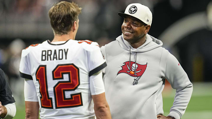 Jan 8, 2023; Atlanta, Georgia, USA; Tampa Bay Buccaneers quarterback Tom Brady (12) talks to offensive coordinator Bryan Leftwich on the field prior to the game against the Atlanta Falcons at Mercedes-Benz Stadium. Mandatory Credit: Dale Zanine-Imagn Images