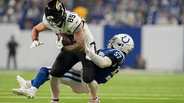 Indianapolis Colts linebacker Jaylon Carlies (57) works to bring down Jacksonville Jaguars tight end Luke Farrell (89) on Sunday, Jan. 5, 2025, during a game against the Jacksonville Jaguars at Lucas Oil Stadium in Indianapolis.