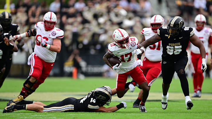 Sep 28, 2024; West Lafayette, Indiana, USA; Nebraska Cornhuskers wide receiver Jacory Barney Jr. (17) is tackled by Purdue Boilermakers linebacker Yanni Karlaftis (14) and defensive lineman Joe Anderson (95) at Ross-Ade Stadium.