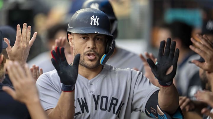Sep 16, 2025; Minneapolis, Minnesota, USA; New York Yankees designated hitter Giancarlo Stanton (27) celebrates with teammates in the dugout after hitting a RBI sacrifice fly against the Minnesota Twins in the first inning at Target Field. Mandatory Credit: Jesse Johnson-Imagn Images