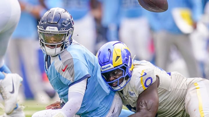 Tennessee Titans quarterback Cam Ward fumbles the ball after a hit by Los Angeles Rams linebacker Byron Young.